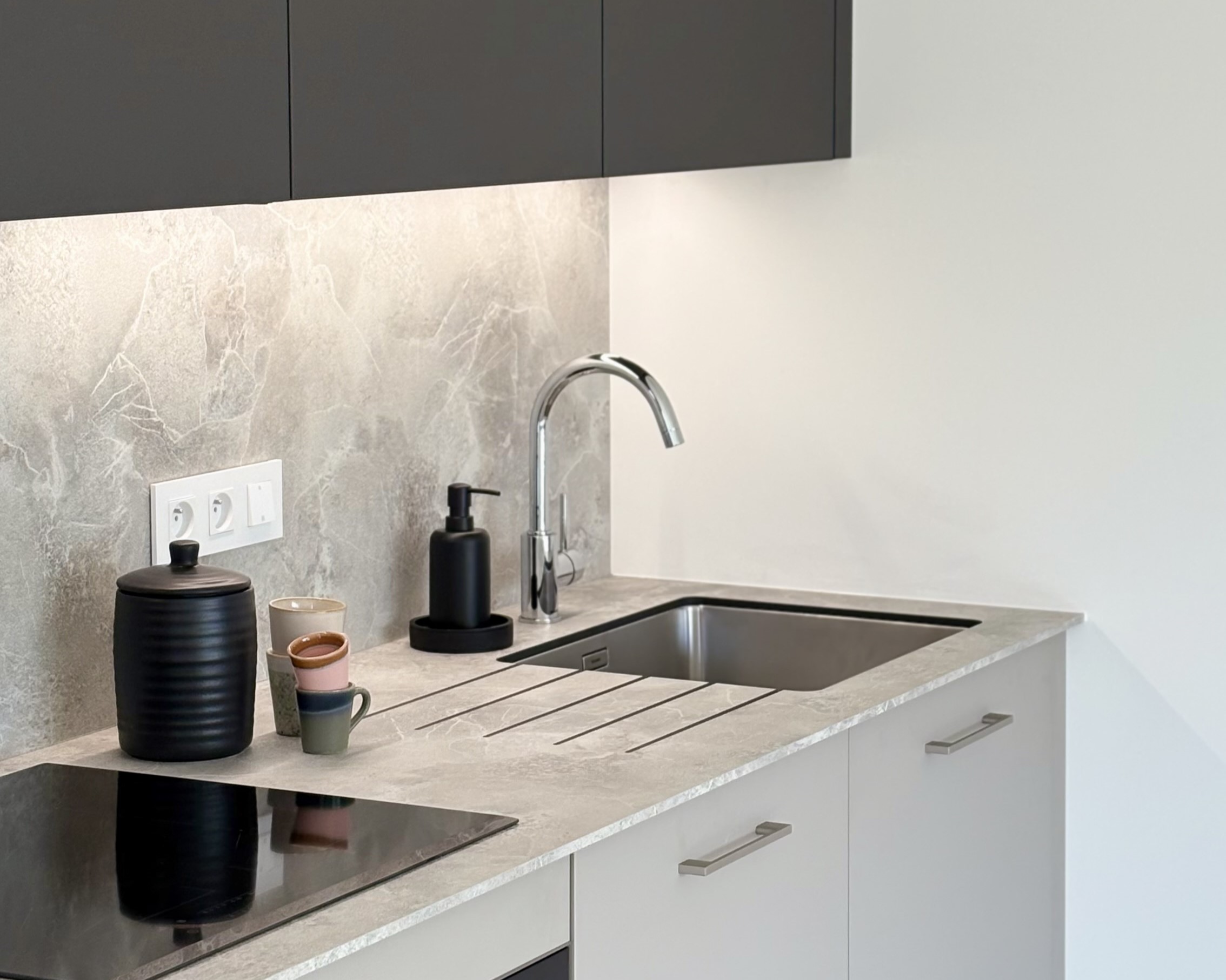 Zoom sur la crédence minérale soulignée par un ruban LED