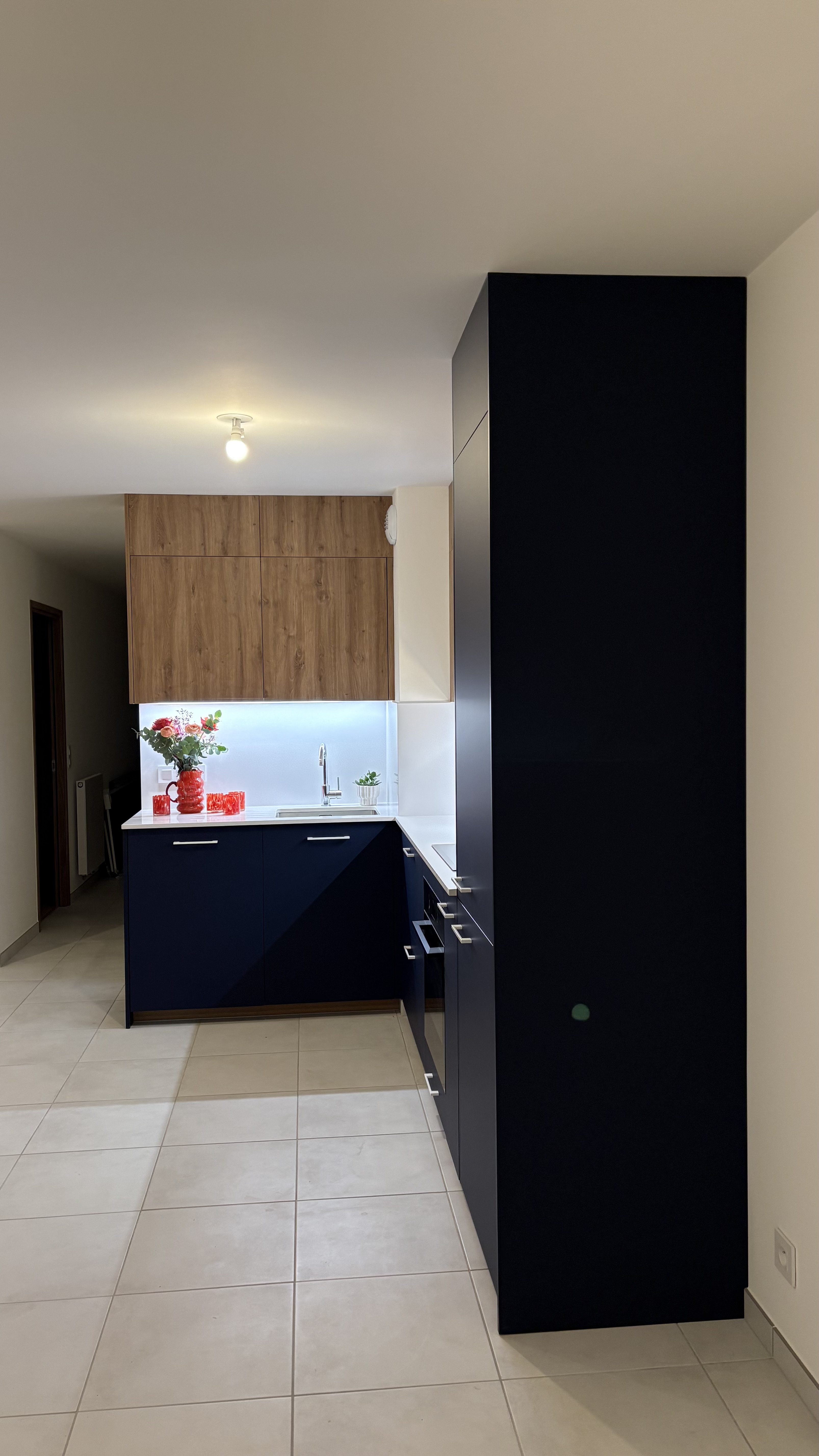 Vue d'une nouvelle perspective de la cuisine sur mesure bleu et chêne